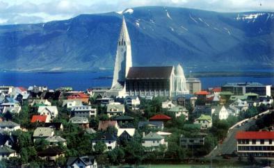 Krásný snímek letního středu Reykjavíku, dominuje chrám Hallgrímskirkja, v dáli masiv Esja (© Rafn Hafnfjörð, NO. 4034)